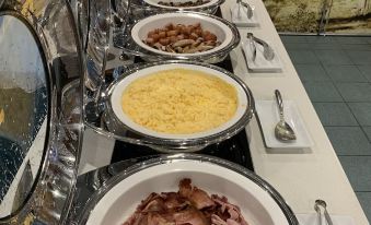 a buffet table filled with various dishes , including bacon and macaroni and cheese , along with a variety of desserts at Quality Hotel Robertson Gardens