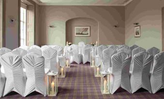 a room with rows of chairs and tables set up for a formal event , possibly a wedding reception at Actons Hotel Kinsale
