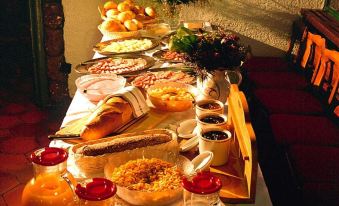 a long table with a variety of food items , including bread , pastries , and other dishes at Matterhorn Inn