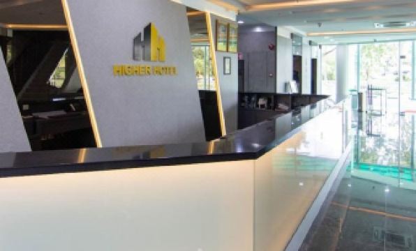 a modern office space with a black and white checkered floor , a reception desk , and several chairs at Higher Hotel