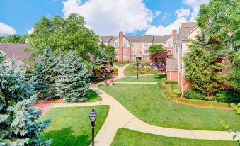 a large , well - maintained residential area with multiple houses and trees , as well as a park - like setting with a winding path leading to at Residence Inn Saddle River