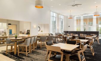 a modern dining room with a long wooden table , several chairs , and several potted plants at Homewood Suites by Hilton Salt Lake City Draper