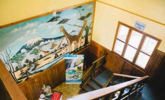 a staircase with a mural on the wall , featuring a giraffe and various objects such as books and posters at Keys Hotel