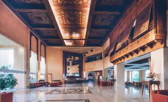 a large , spacious hotel lobby with a high ceiling and wooden beams , featuring a marble floor and ornate ceiling decorations at Iberostar Selection Royal El Mansour