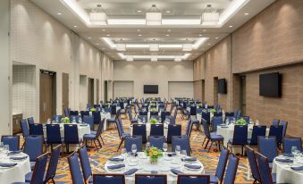 a large banquet hall filled with tables and chairs , ready for a formal event or a wedding reception at Embassy Suites by Hilton South Jordan Salt Lake City