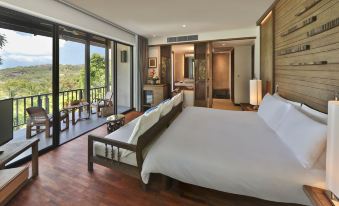 a modern bedroom with a large bed , wooden flooring , and a balcony view of the surrounding area at Pimalai Resort & Spa