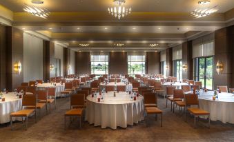 a large , empty banquet hall with multiple round tables and chairs set up for an event at Hyatt Place Hampi