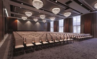 a large conference room with rows of chairs arranged in a semicircle , creating an auditorium - like setting at Conrad Algarve