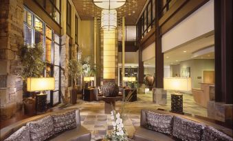 a luxurious hotel lobby with high ceilings , stone walls , and a circular couch in the center at Newpark Resort