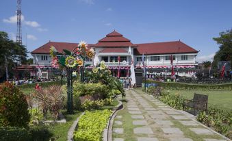 a large building with a red roof is surrounded by colorful flowers and a path at Victoria Bed & Breakfast