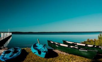 a serene evening view of a lake with boats docked on the shore and a wooden pier extending into the water at Waterfront Retreat at Wattle Point