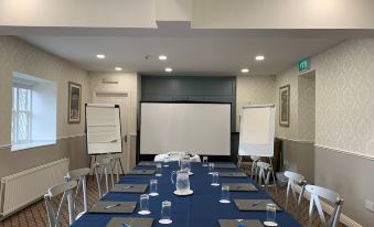 a conference room with a long table , chairs , and a projector screen , ready for a meeting at Leixlip Manor Hotel