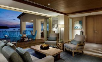 a spacious living room with wooden furniture , including a couch , chairs , and a coffee table at Resorts World Langkawi