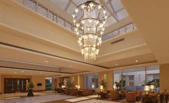 a large , well - lit hotel lobby with high ceilings and a chandelier hanging from the ceiling at DoubleTree by Hilton Agra