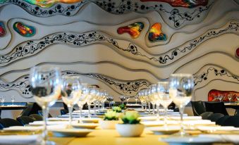 a long dining table with white plates and wine glasses set for a formal meal at Wyndham Nordelta Tigre Buenos Aires