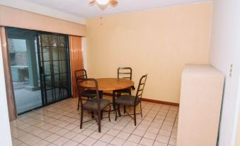 a dining room with a wooden table surrounded by chairs , and a door leading to a patio at La Esperanza