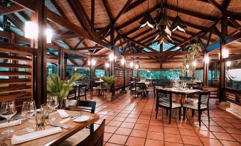 a dining room with wooden tables and chairs arranged for a group of people to enjoy a meal together at Tabacon Thermal Resort & Spa