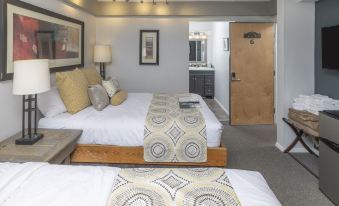 a bedroom with a large bed and white sheets , featuring a geometric pattern on the bed at Ski Inn