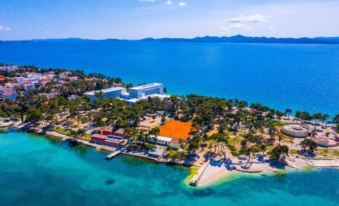 a bird 's eye view of a tropical island with a large orange building and a clear blue ocean at Hotel Pinija