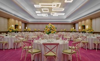 a large dining room with multiple tables and chairs arranged for a formal event , possibly a wedding reception at Holiday Inn Resort Goa