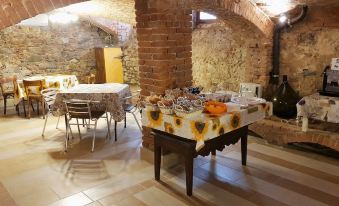 a room with brick walls and wooden tables , a dining area with food on the table at La Fornace