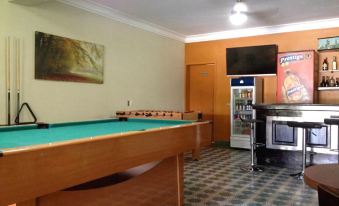 a pool table is in the middle of a room with a vending machine and a refrigerator nearby at Hotel La Cretonne