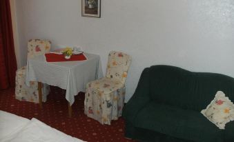 a small living room with a couch , a dining table , and two chairs arranged around it at Berghof