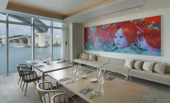 a dining room with a large window overlooking the water , creating a serene and tranquil atmosphere at Hotel Anteroom Naha