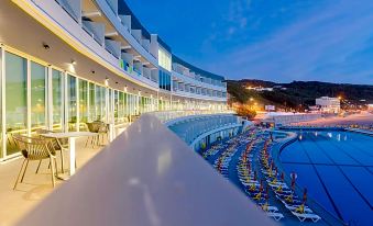a large , modern hotel with multiple balconies and outdoor seating areas , situated near a body of water at Arribas Sintra Hotel