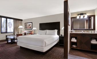 a large bed with white sheets and a brown headboard is in a hotel room at DoubleTree by Hilton Phoenix Tempe