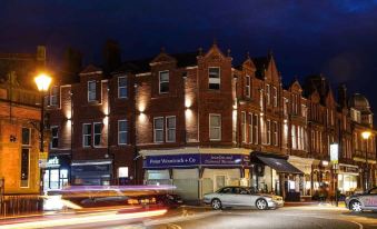 a nighttime street scene with a brick building on the left side of the street at Mode Hotel Lytham
