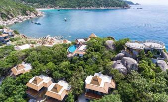 a resort with multiple buildings and a swimming pool situated on the side of a cliff , overlooking a body of water at Sai Daeng Resort