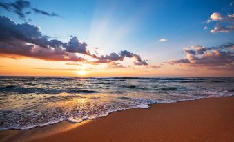 a beautiful beach scene with waves crashing onto the shore and a beautiful sunset in the background at Ras Al Jinz Turtle Reserve