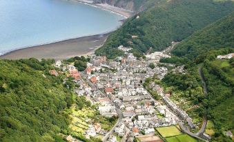an aerial view of a coastal town nestled in a valley with mountains and a river running through it at The Crown Hotel