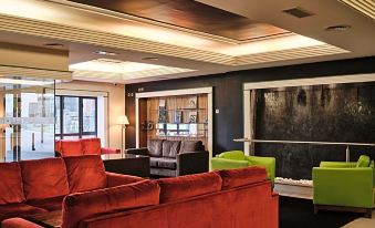 a modern office space with a large window , black ceiling , and red sofas arranged in a living room area at The Prince of Wales Hotel