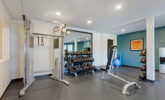 a well - equipped gym with various exercise equipment , including a treadmill and weights , in a spacious room at Best Western Plus Novato Oaks Inn
