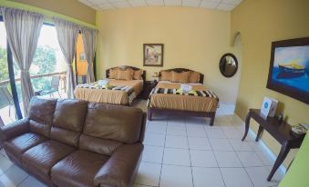 a living room with two beds , one on each side of the room , and a couch in the corner at Hotel Estero y Mar