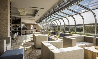 a large , modern restaurant with multiple dining tables and chairs , as well as a bar area at Hotel Histrion