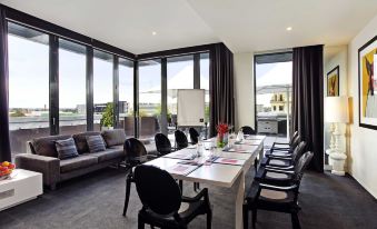 a large conference room with a long table , multiple chairs , and a window overlooking the city at The Cullen Melbourne - Art Series