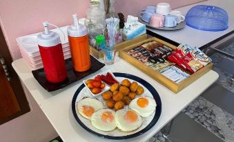 a breakfast table with a variety of food items , including eggs , sausages , and other dishes at The Linux Garden Hotel