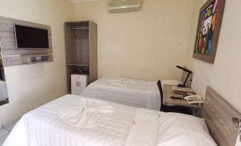 a hotel room with two white beds , one on the left and one on the right side of the room at Hotel Boulevard