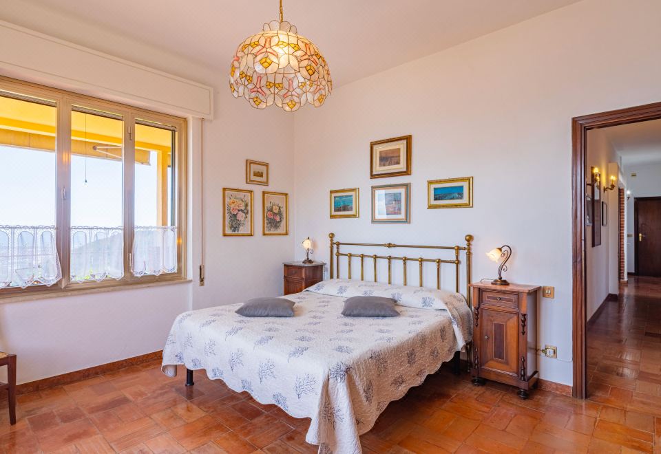 a large bedroom with a wooden floor , a large bed , and a chandelier hanging from the ceiling at Agave