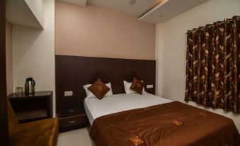 a clean and well - organized bedroom with a large bed , two pillows , and a brown comforter at Holiday Inn