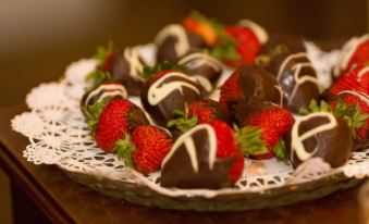 a plate of chocolate - covered strawberries with white chocolate drizzled over them and garnished with strawberries at The Brandon Inn