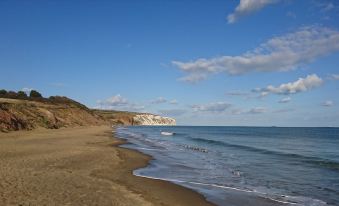 a sandy beach with a cliff in the background and a body of water in the foreground at Sandown Manor