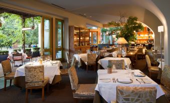 a well - lit restaurant with multiple tables and chairs , some of which are set for dining at Hotel Healdsburg