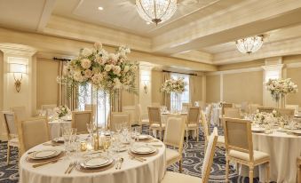 a formal dining room set up for a wedding reception , with multiple tables and chairs arranged for guests at Lafayette Park Hotel & Spa