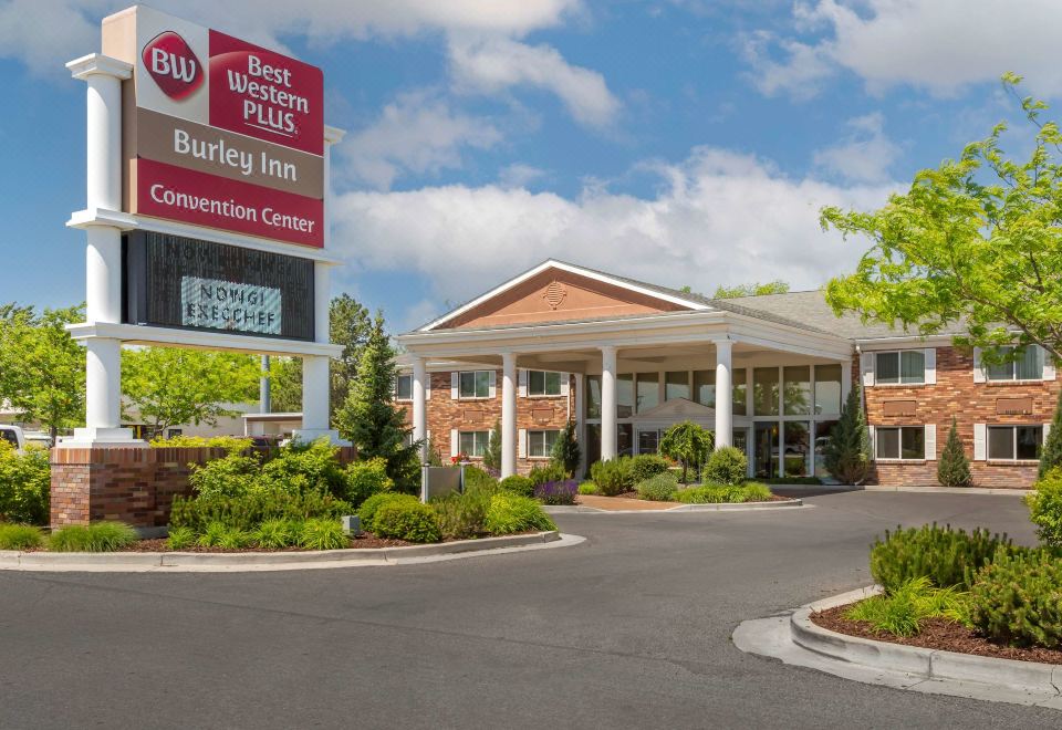an exterior view of a hotel or motel with a large building in the background at Best Western Plus Burley Inn  Convention Center