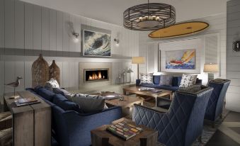 a cozy living room with blue and gray furniture , including a couch , chairs , and a coffee table at Nantasket Beach Resort