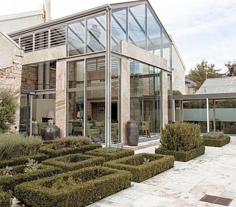 a modern house with a large glass window and a brick pathway leading up to it at Islington Hotel